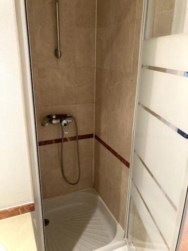 une douche avec une porte vitrée dans une salle de bain dans l'établissement Studio Le Touquet, à Le Touquet-Paris-Plage
