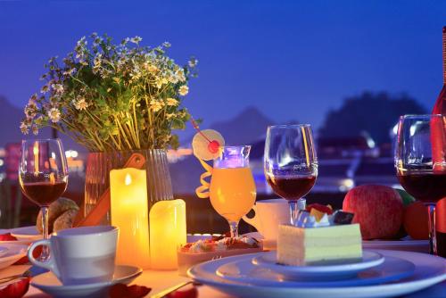 a table topped with glasses of wine and food at Sky Garden Inn in Guilin
