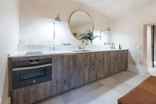 una cucina con lavandino e specchio di Sofisticado apartamento en frente a la playa a Málaga