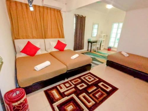 a bedroom with two beds with red pillows at Fishing Village Marang Terengganu in Marang