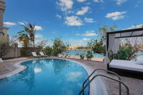 a swimming pool with a view of the water at Maison Privee - Palm Jumeirah Beach Front XL Villa with Private Pool in Dubai