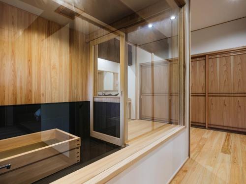 a kitchen with wooden cabinets and a glass wall at RITA Izumifumoto in Izumi