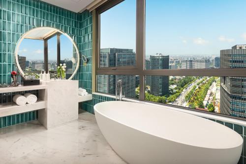 上海的住宿－上海大华长风华邑酒店，带浴缸的浴室和大窗户