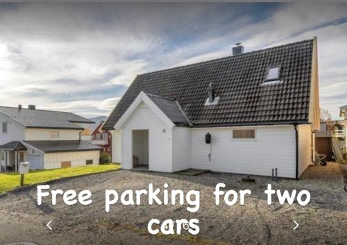 a white house with a garage with the words free parking for two cars at Polar Arctic Luxury House - Free parking in Tromsø