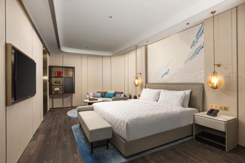 a hotel room with a bed and a television at HUALUXE Shanghai Changfeng Park - Park Lake View in Shanghai