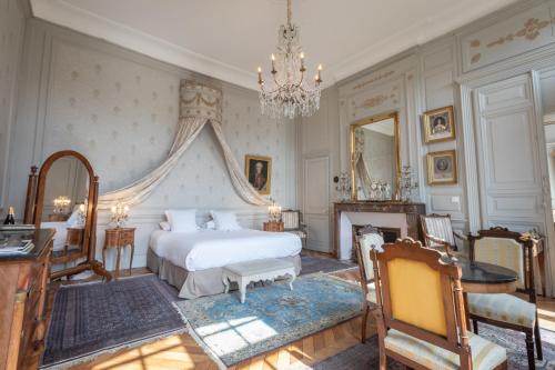 a bedroom with two beds and a chandelier at L'Hotel de Panette, Un exceptionnel château en ville in Bourges