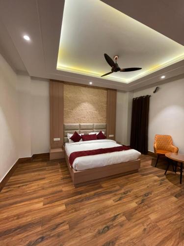 Hotel Crown Savoy, Near Railway Station & GURU NANAK DEV UNIVERSITY في أمريتسار: غرفة نوم بسرير ومروحة سقف