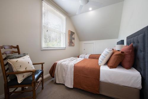 a bedroom with two beds and a chair at Noonameena in Hepburn