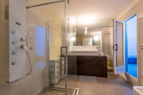 W łazience znajduje się szklana kabina prysznicowa i umywalka. w obiekcie Design Apartment with private pool exclusive use - Stelvio 21 w Mediolanie