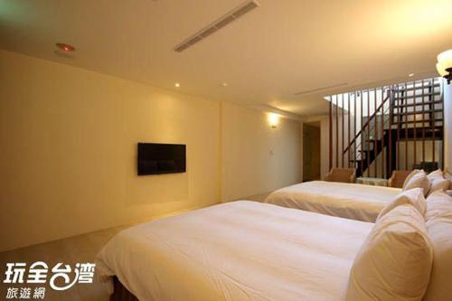 a hotel room with two beds and a television at Jing Guan Hotel in Eluan