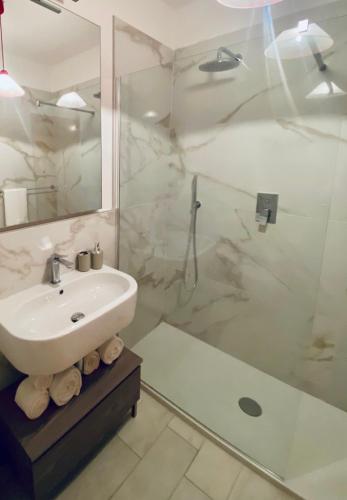 a white bathroom with a sink and a shower at Donoratico Comfort and Relax on the Etruscan Coast in Donoratico