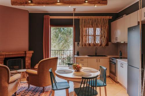 cocina con mesa y sillas y comedor en Kalavrita Krinides Apartments and Attics, en Kalavrita