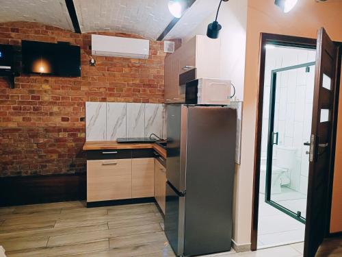 cocina con nevera y pared de ladrillo en Pokoje Jola, en Drawsko Pomorskie