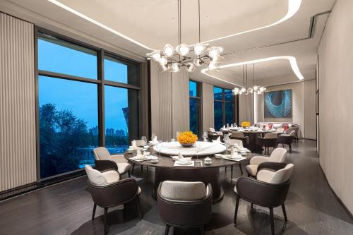 a dining room with a long table and chairs at HUALUXE Shanghai Changfeng Park - Park Lake View in Shanghai