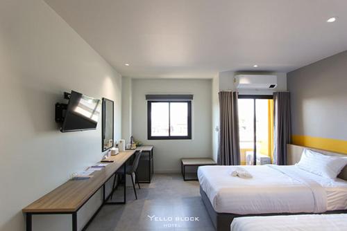 a hotel room with two beds and a desk at Yello Block Hotel 