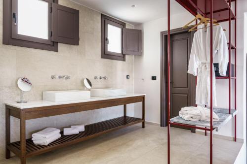 a bathroom with a sink and a mirror at Pelican Bay Hotel in Platis Yialos Mykonos