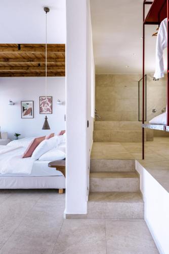 a bedroom with two beds and a staircase at Pelican Bay Hotel in Platis Yialos Mykonos