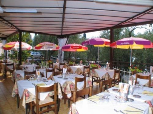 a restaurant with tables and chairs with umbrellas at Hotel Rabay in Brenzone sul Garda