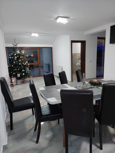 a dining room with a christmas tree and a table and chairs at Casa Cristina in Cîrţişoara