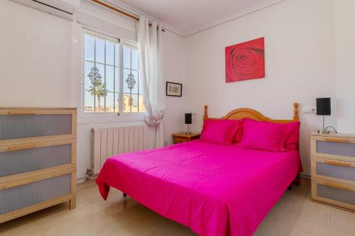 1 dormitorio con cama rosa y ventana en 3 Bedroom Holiday Villa Benani en Puerto Marino