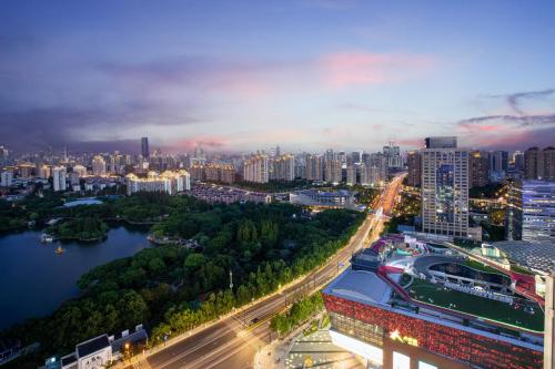 a city skyline at night with a river and buildings at HUALUXE Shanghai Changfeng Park - Park Lake View in Shanghai