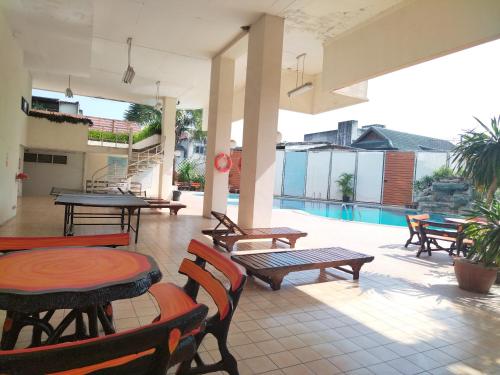 a patio with tables and chairs and a pool at Supanich condo opposite the Train Station ChiangMai in Chiang Mai