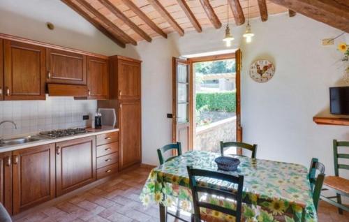 a kitchen with a table with chairs and a table and a window at Agriturismo Casale Giulia in Volterra