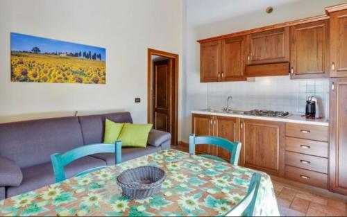 a living room with a table and a kitchen at Agriturismo Casale Giulia in Volterra