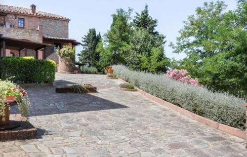 a garden with a stone walkway next to a building at Agriturismo Casale Giulia in Volterra