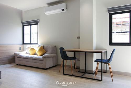a living room with a couch and a table at Yello Block Hotel 