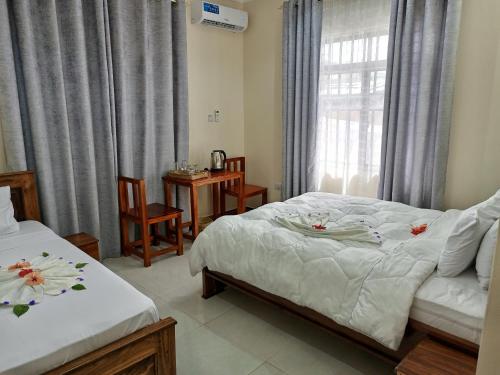 a bedroom with two beds and a window at Kendwa Cool and Calm Hotel limited in Kendwa