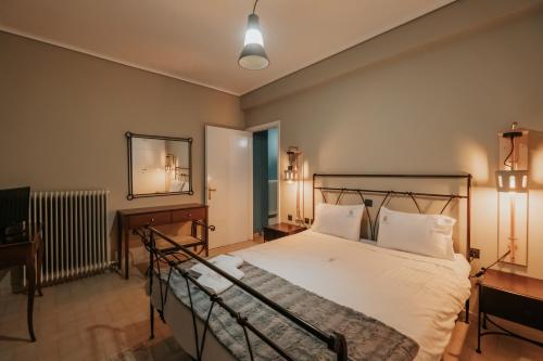 a bedroom with a bed and a mirror at Kalavrita Krinides Apartment and Attics in Kalavrita
