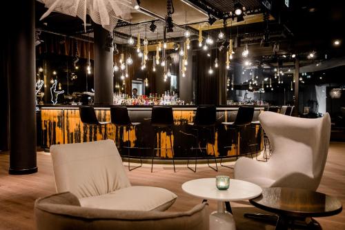 a room with chairs and a bar in the background at Motel One Stuttgart-Mitte in Stuttgart