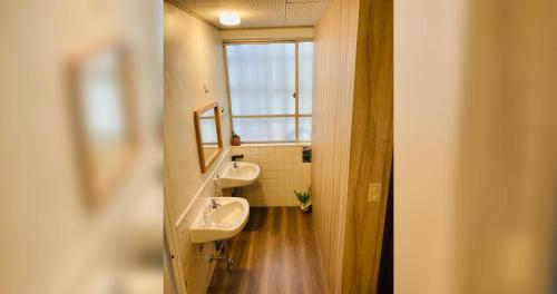 a bathroom with two sinks and a window at ペンションやいま日和 in Ishigaki Island