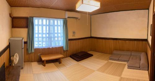 a small room with a couch and a window at ペンションやいま日和 in Ishigaki Island