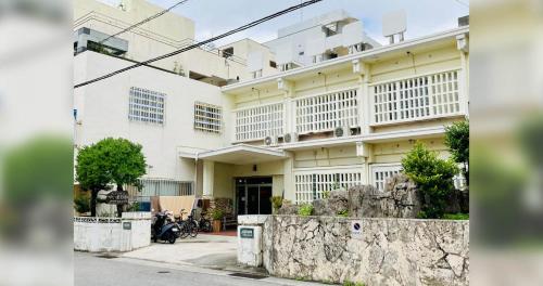 a white building with windows on the side of it at ペンションやいま日和 in Ishigaki Island