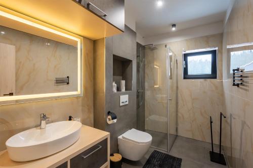 W łazience znajduje się umywalka, toaleta i prysznic. w obiekcie Chalet Malino - Apartments w Rużomberku