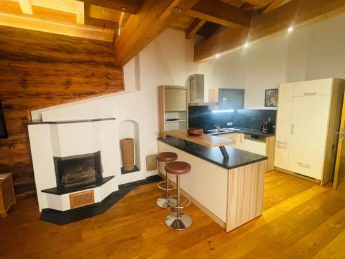 a kitchen with a stove and a counter with stools at Natursport Heutal Appartements in Unken