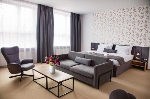 um quarto de hotel com uma cama e um sofá em Family Resort Lučivná em Lučivná