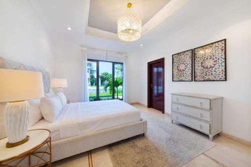 a bedroom with a bed and a table with a lamp at Maison Privee - 5 Stars Villa with Private Pool or Beach on Palm Jumeirah in Dubai