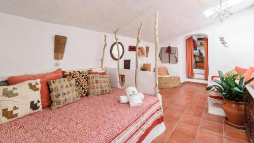 um quarto com uma cama com almofadas em Casa Belmonte Alcaucín by Ruralidays em Alcaucín