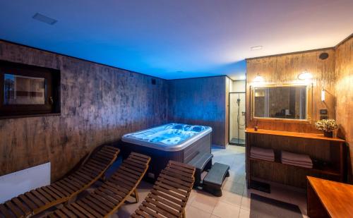 um quarto com uma banheira e duas cadeiras em Bregec Tiny House and Wellness em Varaždinske Toplice