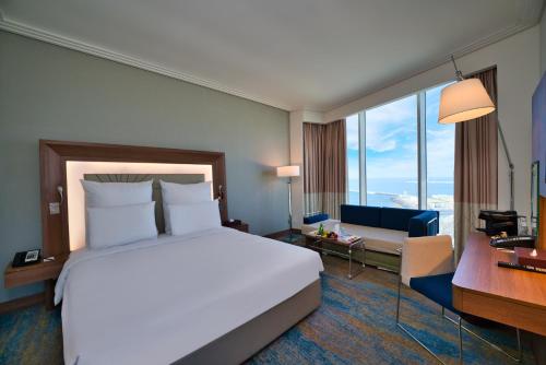 a hotel room with a large bed and a desk at Novotel Jazan in Jazan