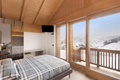 sypialnia z łóżkiem i dużym oknem w obiekcie Plaz w Livigno