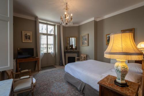 ブールジュにあるL'Hotel de Panette, chambres indépendantes - entrée sainte Chapelleのベッドルーム1室(ベッド1台、テーブルの上にランプ付)