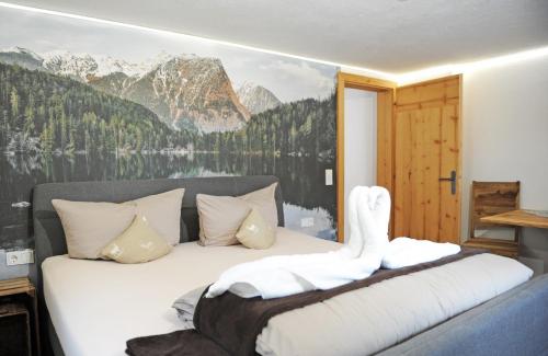 a bedroom with a bed with a mountain mural on the wall at Apart Oetz in Oetz