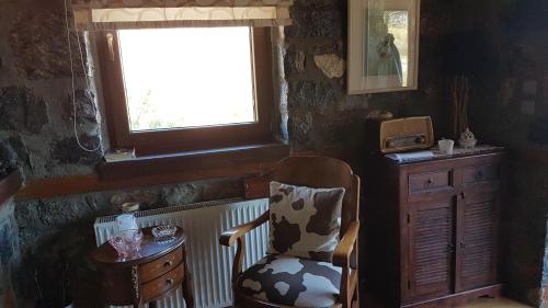 a room with a chair and a table and a window at Mountain house in Palaios Agios Athanasios