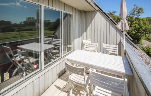 a patio with a table and chairs on the side of a house at Awesome Home In Samsø With Kitchen in Onsbjerg
