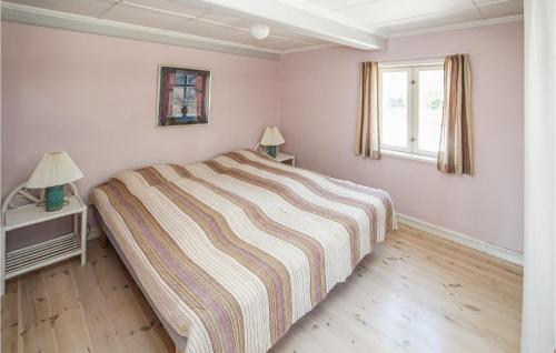 a bedroom with a large bed with a striped blanket at Awesome Home In Samsø With Kitchen in Onsbjerg