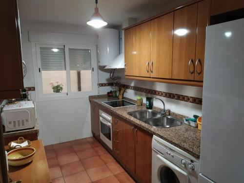 格哈爾謝拉的住宿－Apartamento Guejar Sierra，厨房配有木制橱柜、水槽和洗碗机。